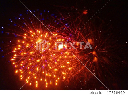 天然デザイン花火の背景素材・夜空に開く打ち上げ花火の火と煙りの軌跡・橙系大輪と背後に青い大輪横位置 17776469