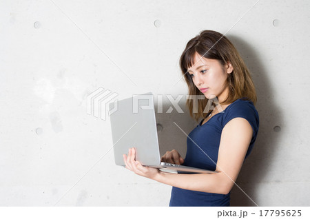 かっこよくパソコンで作業する女性イメージ　コンクリート壁背景　クロスプラザ内 17795625