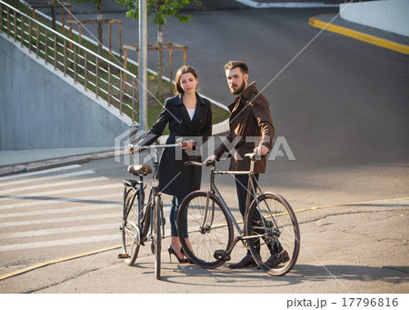 Young couple with on a bicycle opposite city  17796816