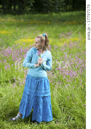 beautiful young woman in a blue dress in the field 17797278