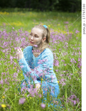 beautiful young woman in a blue dress in the field 17797280