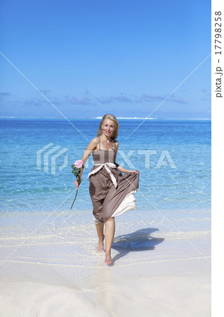 woman with a rose runs on the edge of the sea on a woman with a rose runs on the edge of the sea on a 17798258