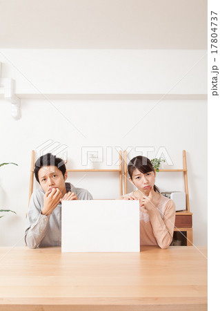 困った顔でホワイトボードを持つ男女カップル 17804737