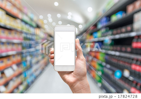 Female hand holding mobile smart phone on Supermarket blur backg 17824728
