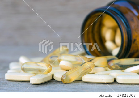 Pills or vitamin in Medicine bottles on wood background 17825305