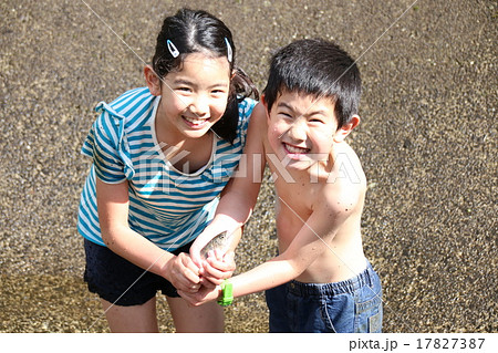 魚つかみをする男の子と女の子の写真素材