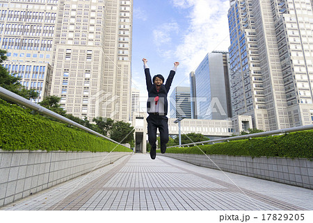 アクションポーズ　ジャンプするビジネスマン　ブレ　新宿高層ビル街　万歳ポーズ 17829205