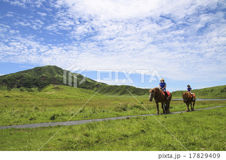 阿蘇山の草千里ヶ浜にて親子で乗馬の写真素材