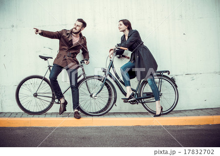 Young couple with a bicycle opposite city  17832702
