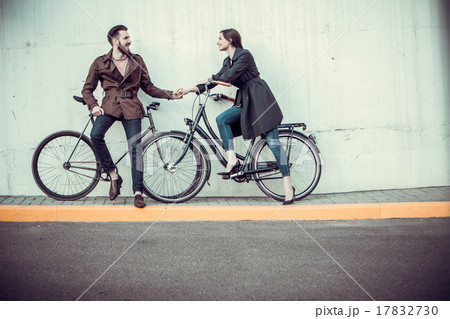 Young couple with a bicycle opposite city  17832730