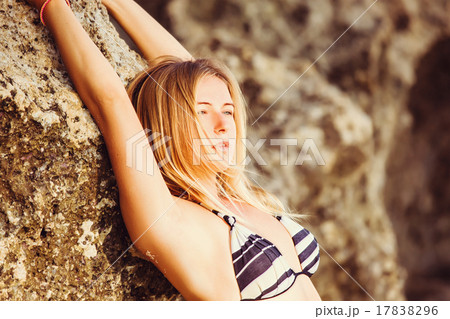 Young blonde girl in bikini leaning over a rock on Young blonde girl in bikini leaning over a rock on 17838296