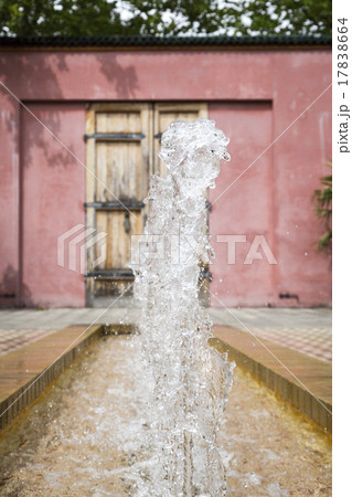 fountain in an oriental garden with red wall 17838664