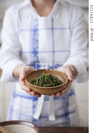 ほうれん草の胡麻和えを載せた皿を持つ女性 17841722