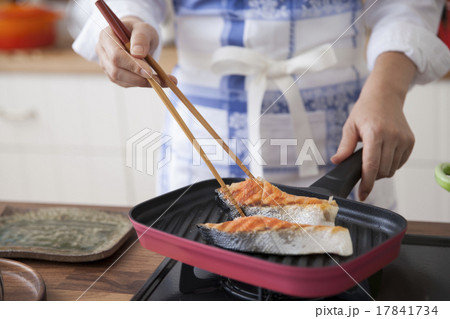 塩鮭をグリルパンで焼く女性 17841734