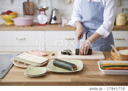 巻き寿司を包丁で切り分ける女性 17841758