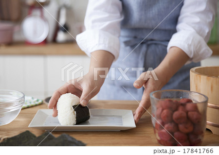 おにぎりを皿に載せる女性 17841766