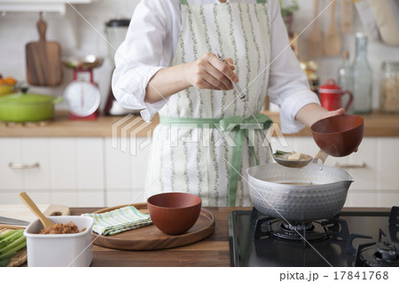 鍋から椀に玉杓子で味噌汁をよそう女性 17841768