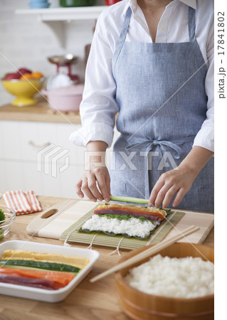海苔に酢飯と具材を載せ巻き寿司を作る女性 海苔に酢飯と具材を載せ巻き寿司を作る女性 17841802