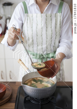 鍋から椀に玉杓子で味噌汁をよそう女性 17841810