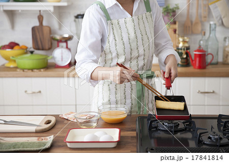 玉子焼き器で出汁巻き玉子を焼く女性 17841814