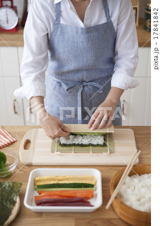 巻き簾で海苔と酢飯を巻いて太巻を作る女性 17841842