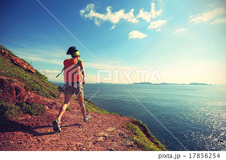 woman backpacker walking on seaside mountain trail 17856254