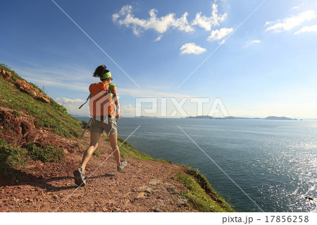 woman backpacker walking on seaside mountain trail 17856258