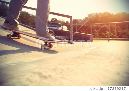 skateboarder legs riding skateboard at skatepark 17859217