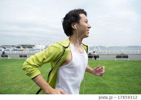 Happy young asian man running in city park 17859312