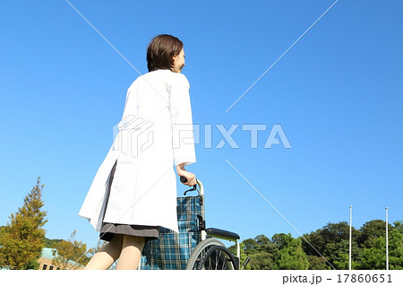 車椅子と白衣の女性 後ろ姿 の写真素材