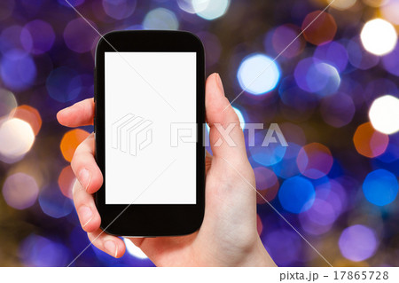 hand with smartphone on dark violet background 17865728