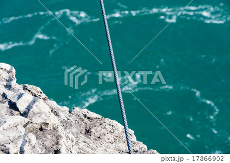 Tight steel cable over rock edge and river 17866902