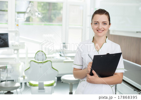 Cheerful female dentist is making notes in lab 17868395