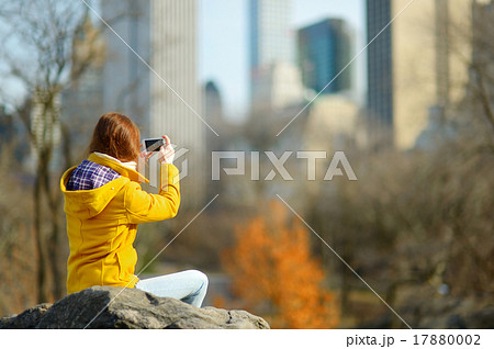 Beautiful young woman taking a photo of skyscapers Beautiful young woman taking a photo of skyscapers 17880002