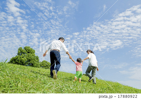 公園を歩く親子の後ろ姿の写真素材