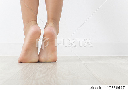 背伸びをする子供の足元の写真素材