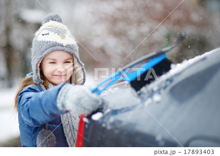 Adorable little girl helping to brush a snow 17893403