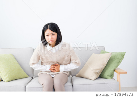 女性　ポートレート　腹痛　腹下し　女性　体調不良　若年層　白背景　ホワイトバック　コピースペース 17894572