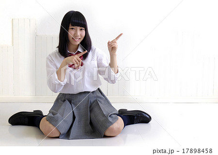 女子高生 座り両手指差しの写真素材 女子高生 座り両手指差しの写真素材