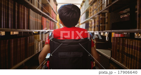 Composite image of rear view of boy sitting in wheelchair 17906640