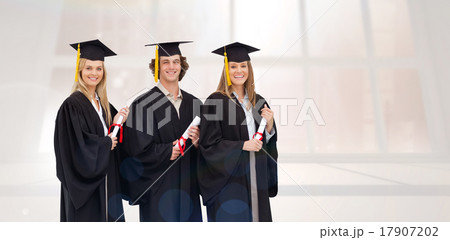Composite image of three smiling students in graduate robe holdi 17907202