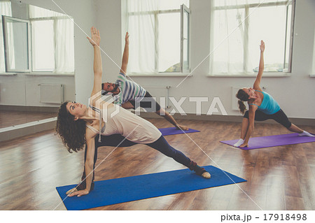 Group of people are doing yoga indoors 17918498