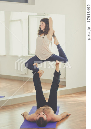 Sportive couple are doing acro-yoga indoors 17918499