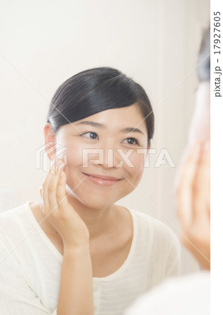鏡越しにスキンケアをする30代の女性 17927605