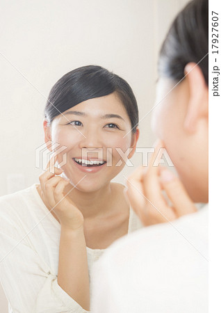 鏡越しにスキンケアをする30代の女性 17927607