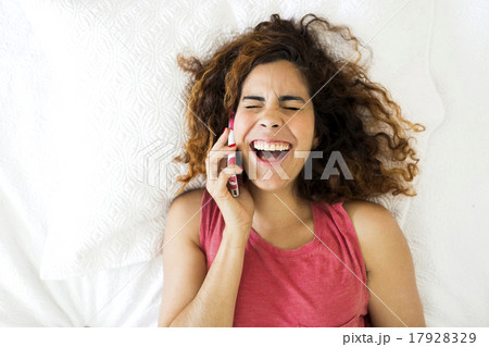 Woman using phone in bed Woman using phone in bed 17928329