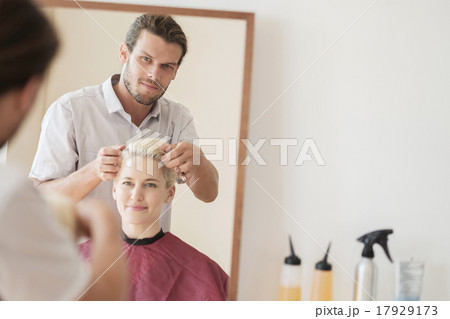 Hairdresser combing woman's hair 17929173