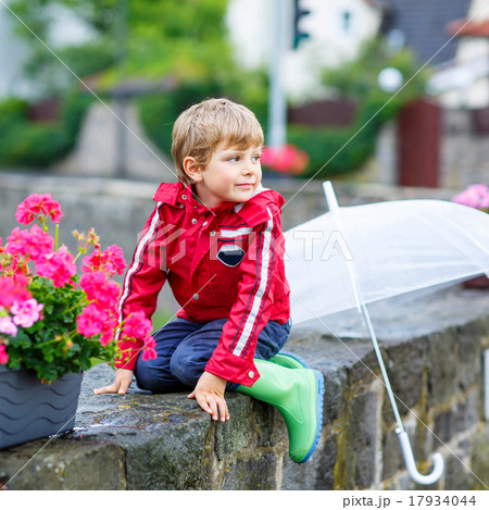 Little blond kid boy with big umbrella outdoors Little blond kid boy with big umbrella outdoors 17934044