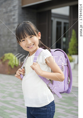 自宅の前に立つ小学生の女の子の写真素材
