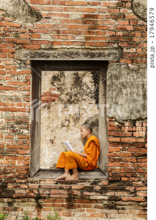 Novice monk reading  books in ruins. 17946579